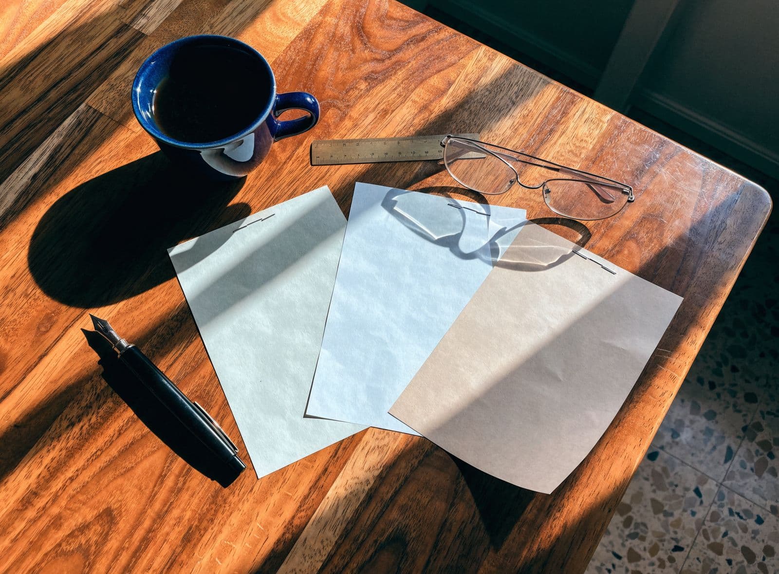 Three quotations fanned across a walnut table with a pen, a cup of coffee and a pair of glasses.
